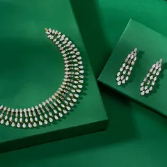 This elegant American Diamond necklace set features cascading tiers of marquise-cut stones. The matching drop earrings complete the look, offering a modern and sophisticated sparkle.