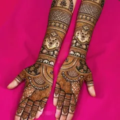This elegant design features delicate jaal (net) patterns on the forearms. The palms have a beautiful layout with elephant motifs at the base of the fingers.