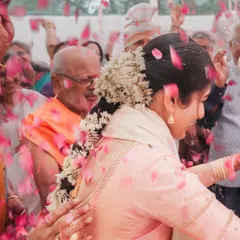 A beautiful candid of the bride dancing, enveloped in a shower of flower petals. This action shot perfectly captures the festive spirit of an Indian wedding.