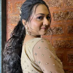 A side view of a modern, curly ponytail with butterfly accessories. This is a popular choice for sangeet or cocktail events.