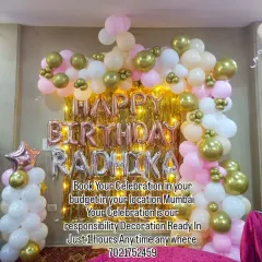 A sweet and simple home decoration for Radhika's birthday. The balloon arch in pink, white, and gold, along with the foil name banner, creates a lovely backdrop against the shimmer curtain.