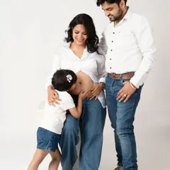 A kiss for the new baby. This is such a precious moment, capturing the older sibling's love for their new brother or sister on the way.