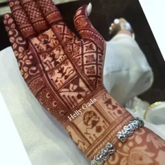 The rich, dark stain of the Warli art design. The geometric shapes and simple figures of the Warli paintings look even more striking with the deep henna color.