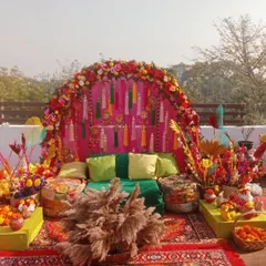 A perfect rooftop Mehandi setup with a vibrant, bohemian vibe. We used a floral arch, colourful tassels, low seating with gaddas, and lots of props for a festive and photogenic event.