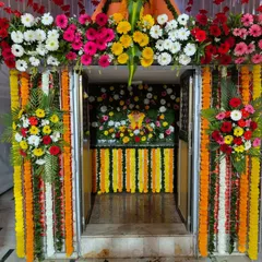 A closer look inside a pandal, where we decorated the inner sanctum. The entrance to the idol is framed with colorful gerbera daisies and marigold garlands, creating a beautiful focal point.