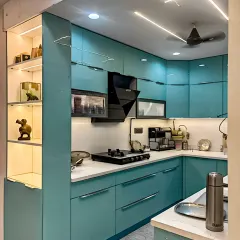 This modern kitchen showcases sleek, turquoise-colored cabinets with a glossy finish. A built-in display shelf with internal lighting adds a decorative touch, while the white countertop keeps the look fresh.