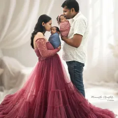 Double the love, double the joy. This portrait of newborn twins with their parents is incredibly special. The mother's flowing gown and the tender way they hold their babies create a magical family photo.