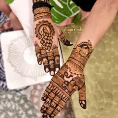A beautiful composition showing two different hands, one with a dancing peacock and the other with a more intricate, figure-filled design. This highlights our ability to create both focused and elaborate patterns.