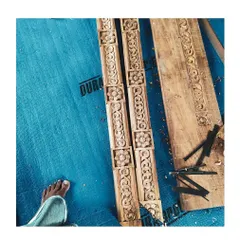 A close-up of freshly carved wooden components for a door frame, laid out on-site. Every detail is carefully considered and executed by talented craftspeople under our supervision.