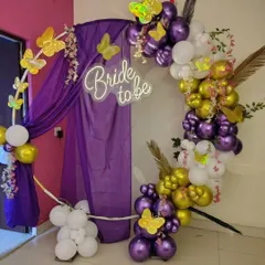 A whimsical 'Bride to be' decoration in purple, gold, and white. I used a circular frame with drapes, a balloon garland, and butterfly accents for a unique look.