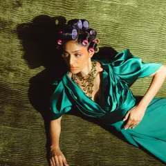 From the 'Vibrant Retroad' shoot, this overhead shot highlights the retro-inspired hair set in rollers and the soft, 70s-style makeup with its warm blush and defined eyes.