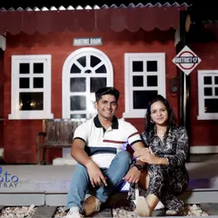 A fun shot on the railway tracks of the station set. This pose adds a playful element to the travel-themed pre-wedding photoshoot.
