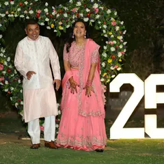 The happy couple celebrating their 25th anniversary in front of the custom backdrop I designed for their special day.