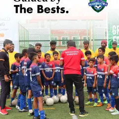 Guided by the best. Our coaches lead a team huddle, providing instruction and motivation to a group of young, attentive players.