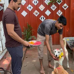 Our staff carefully prepares for the Diwali puja, holding a traditional thali while another team member lovingly places a flower garland on a happy guest.