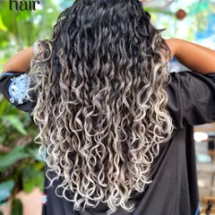 We are obsessed with transforming curls. Here, we achieved a stunning silver ombre on long, curly hair while maintaining the integrity and definition of each curl. This look was created with a careful bleach and tone process, followed by our signature CGM-friendly styling.