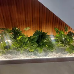 Another view of an under-staircase garden. The wood-paneled background and integrated lighting enhance the lush look of the artificial plants.