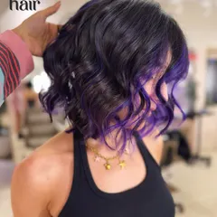 A little bit of purple makes everything better. We gave this client a chic, wavy bob with a purple balayage, adding a pop of vivid colour to her dark base.