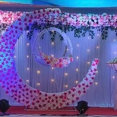 A closer look at the floral moon and cradle setup for a naming ceremony. The twinkling lights in the backdrop and the soft blue and pink lighting create a magical ambiance for the event.