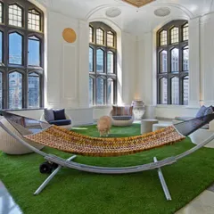 Bringing the park indoors. I installed a large artificial grass area in this grand room to create a unique, relaxed lounge space, complete with a hammock. It’s a bold design choice that adds comfort and a touch of nature.