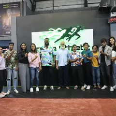 Our female athletes and coaches flexing together with a supporter at our gym. We are proud to foster a strong and empowering environment for women in sports.
