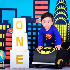 It's a bird, it's a plane, it's Super-baby! This superhero-themed shoot features a cityscape backdrop and a mini Batmobile, perfect for your little hero's first birthday adventure.