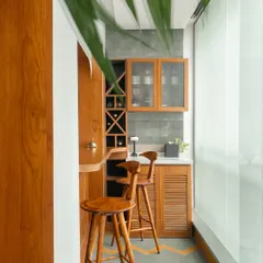 A compact and functional bar nook designed for a residential project. Tucked into a corner, this custom teak wood unit features ribbed tile accents, a built-in wine rack, and chevron-patterned flooring.