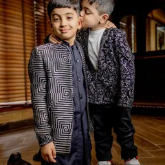 A moment of brotherly love. Our bomber jackets are designed for style and play, as shown by these two handsome boys in their coordinated yet distinct printed jackets.