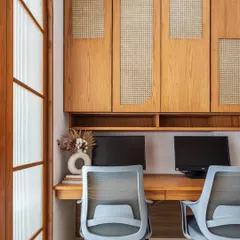 This dual workstation in the nutrition clinic features custom oak cabinetry with arched rattan panels. The design provides ample overhead storage while maintaining a clean, warm, and inspiring work environment.