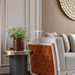 A closer look at the quilted sofa, paired with a fluted side table. This combination of textures, from the tufted fabric to the ribbed table base, creates a rich and layered look.