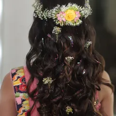 A perfect hairstyle for a Mehendi or Haldi ceremony. I created soft, flowing waves and adorned them with a fresh flower tiara and scattered tiny flowers throughout the hair for a whimsical, bohemian-inspired look.