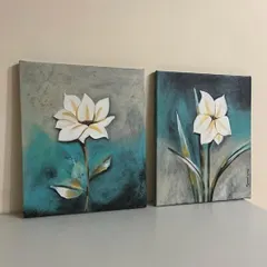 A set of two floral paintings on canvas, showcasing a textured background and clean, elegant flowers. These make for beautiful home decor pieces.