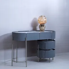 This modern console table features a unique, segmented design with soft grey upholstery and slender metal legs. The tiered, rotating drawers offer a creative storage solution, blending soft textures with a sleek, contemporary structure.