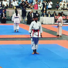 A young competitor stands ready on the tatami mat, focused and prepared for his kata performance at the Independence Cup.