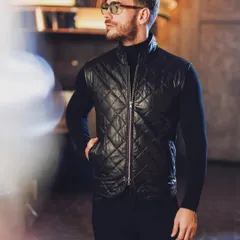 Layering is key to a dynamic wardrobe. Here, a quilted leather gilet adds texture and a modern edge to a simple turtleneck, creating a look that is both functional and stylish.