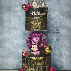 A show-stopping floating cake designed for a Minnie Mouse disco theme. This unique structure features a sparkling disco ball separating two tiers of black and gold cake, detailed with a crown and intricate stenciling.
