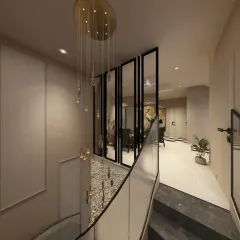 This view from the top of the stairs shows how the foyer connects to the main living areas. The glass railings and partitions maintain an open and airy feel, allowing the light from the chandelier to permeate the adjoining spaces.