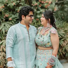 A sweet and simple couple portrait from a pre-wedding event. Their coordinated pastel outfits and the natural green background create a fresh and lovely image.