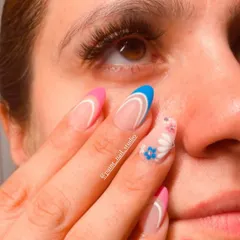 Enhance your sparkle with nails that dazzle and lashes that mesmerize. This close-up shows off a fun, colorful summer manicure设计 and a full set of beautiful lash extensions.
