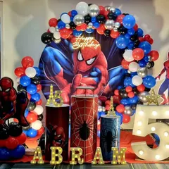 An action-packed Spiderman theme for a 5th birthday. The decoration features a dynamic backdrop of the superhero, balloon columns in red, blue, and black, and a large light-up marquee number '5'.