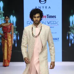 This Indo-Western outfit was part of my runway collection. It features a long, embroidered overcoat worn over a simple light pink kurta and pants, presenting a modern and sophisticated look for special events.