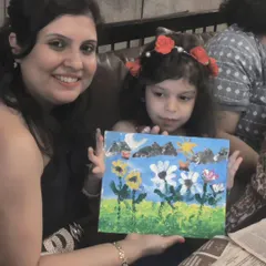 A mother and daughter duo showing their beautiful floral painting, a shared creation from Vazeeshtha's art-themed birthday party.