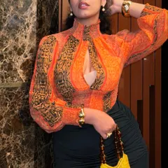 You're staring at a thrift queen. This entire look, from the orange printed top to the yellow crochet bag, is thrifted. I can teach you how to find amazing second-hand pieces and style them into a killer outfit.