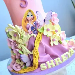 A close-up of the fondant details on the Rapunzel cake, including the character, her dress, and the delicate flowers.