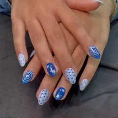 A playful, celestial-themed set with hand-painted stars, swirls, and polka dots in shades of blue. Each nail tells a little part of a starry night story.