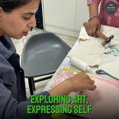 Exploring art is about expressing yourself. Here, a student is engaged in a mixed-media project, learning to combine different materials and textures.