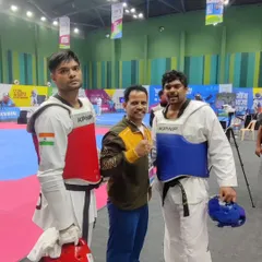 In the corner with two of our state's powerful heavyweight competitors at the National Games. Coaching at this level requires intense focus and strategy.
