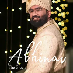 A classic groom portrait in a cream sherwani and turban. The bokeh background and warm lighting create an elegant and celebratory feel.