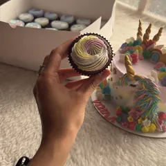 A magical unicorn birthday cake, complete with a golden horn and colorful mane. The matching cupcakes with rainbow frosting completed the enchanting theme for a third birthday party.