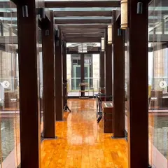The walkway at our New Delhi location, with its polished wooden floors and glass walls overlooking the water body. It sets a tone of modern elegance from the moment you enter.